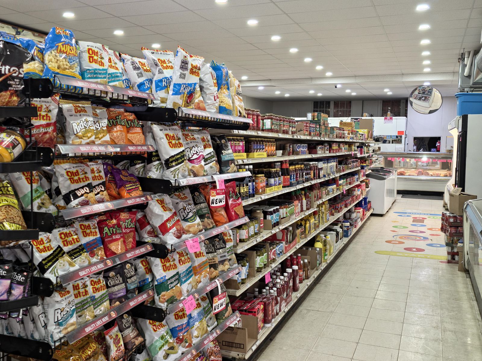 Grocery aisle at Abbi's Payfair stocked with chips, condiments, and pantry items
