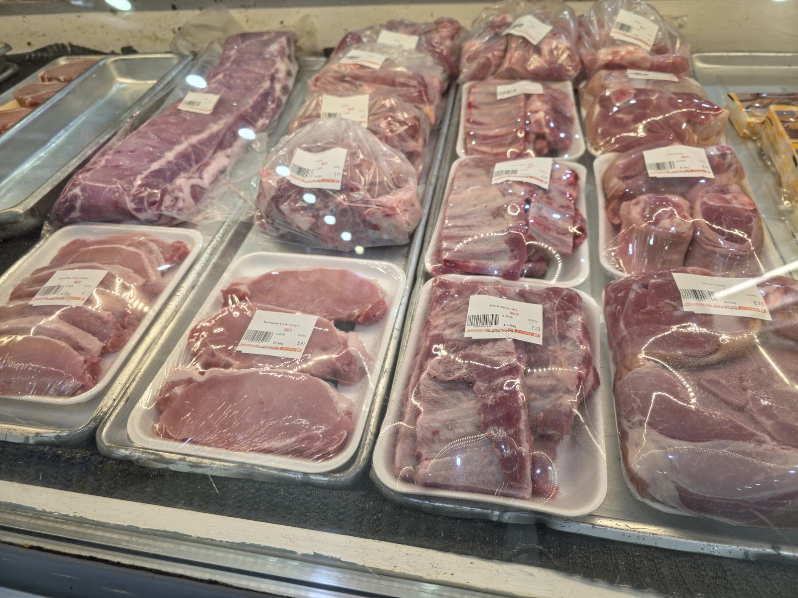 Fresh cut pork chops, side ribs, and pork hocks in the meat case at Abbi's Payfair
